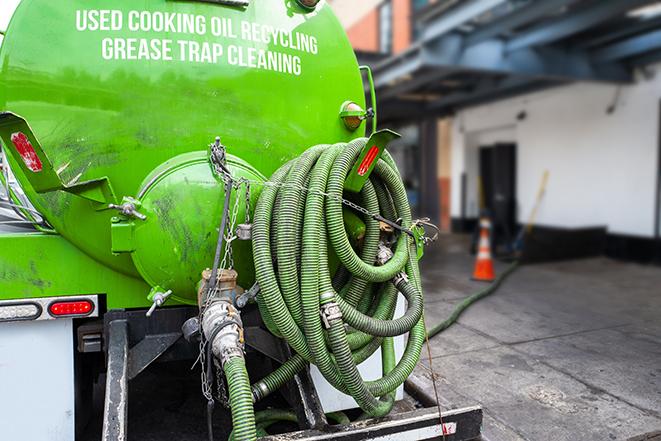 a technician pumping a grease trap in a commercial building in Rock Island